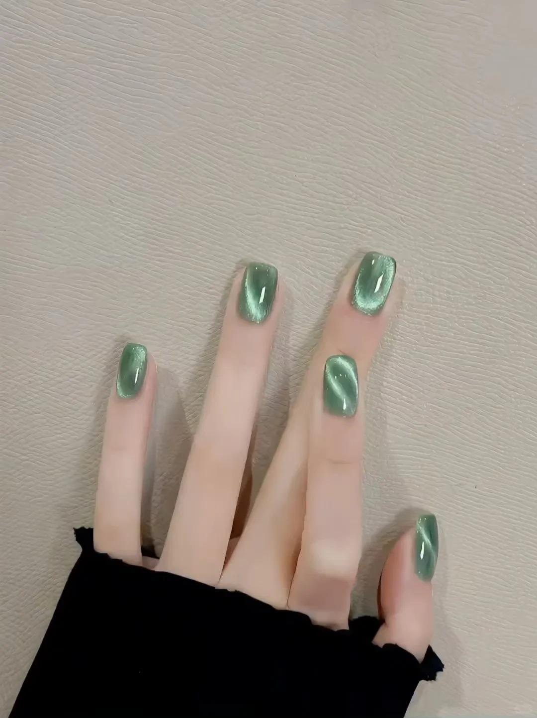 Glossy emerald cat-eye manicure on short square nails