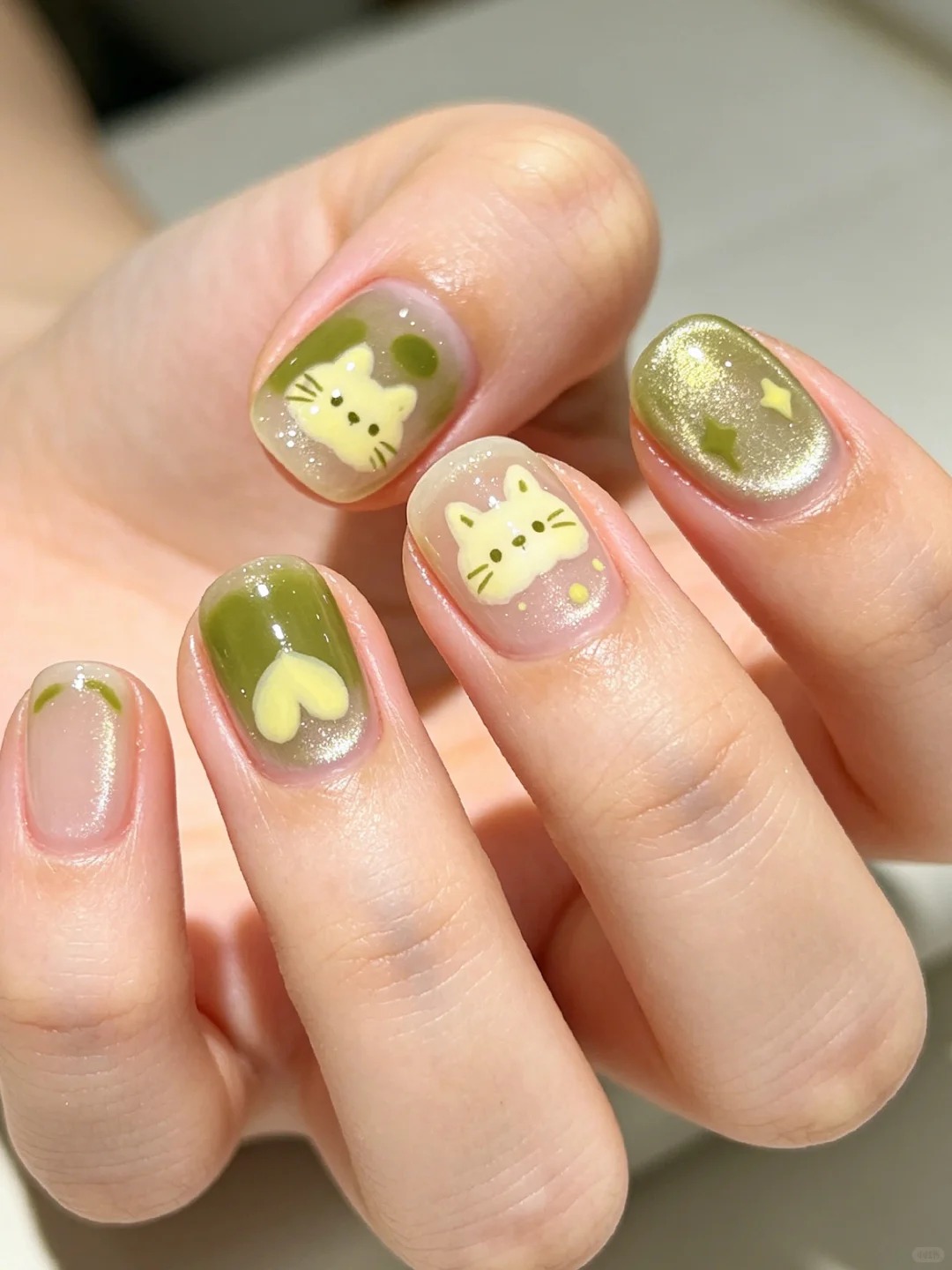 Playful olive green cat nail art on short natural nails